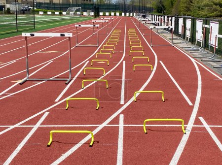 Tall and small hurdle set up on a track for track practice on lanes.