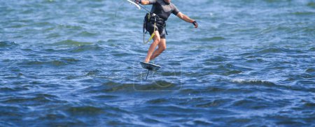 Photo for Front view of a man holding a kite while kite surfing in the Atlantic Ocean. - Royalty Free Image