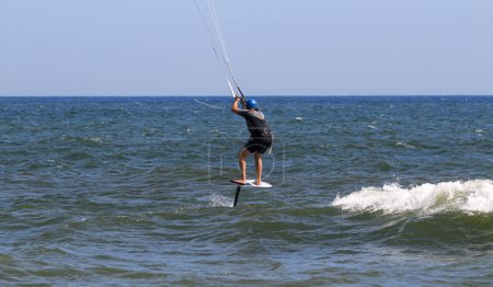 Photo for One man enjoying a kiteboarding ride above the Atlantic ocean off the coast of Long Island. - Royalty Free Image