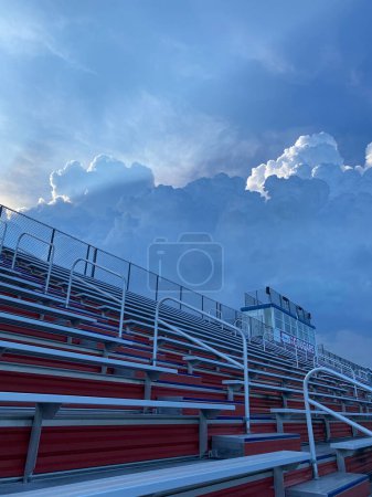 Un conjunto vacío de gradas se sienta bajo un cielo nublado en el fondo, desprovisto de espectadores o actividad. El tiempo parece nublado lluvia inminente.
