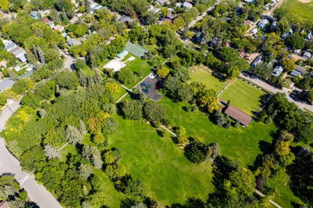 Foto de Descubra la belleza del Parque Ashworth Holmes en Saskatoon. Esta imagen muestra su extenso césped, vibrante parque infantil y lugares de picnic atractivos, un amado espacio verde urbano para todas las edades.. - Imagen libre de derechos
