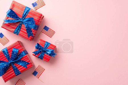 Unabhängigkeitstag der USA. Vertikale Ansicht von Geschenkboxen mit Schleifen und Nationalflaggen auf isoliertem pastellrosa Hintergrund mit leerem Raum