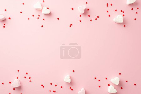 Valentine's Day concept. Top view photo of small heart shaped candies on isolated pastel pink background with copyspace