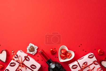 Photo for Valentine's Day concept. Top view photo of gift boxes wine bottle candles plate with heart shaped candies and confetti on isolated red background with copyspace - Royalty Free Image