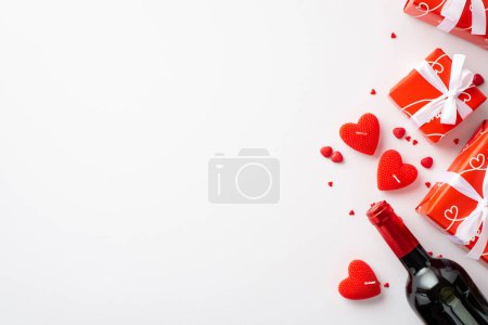 Foto de Valentine's Day concept. Top view photo of red gift boxes with white ribbon bows heart shaped candles wine bottle and sprinkles on isolated white background with copyspace - Imagen libre de derechos
