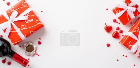 Foto de Valentine's Day concept. Top view photo of red gift boxes heart shaped chocolate candies wine bottle and sprinkles on isolated white background with copyspace - Imagen libre de derechos