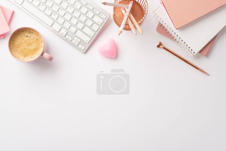 Photo for Valentine's Day concept. Top view photo of workstation keyboard stack of notebooks pencils holder pen heart shaped candle and cup of frothy coffee on isolated white background with copyspace - Royalty Free Image