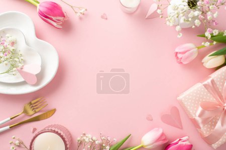 Photo for Modern Mother's day table setting. Top view flat lay of plates, cutlery, tulips, gift box, and decorative hearts on pastel pink background with an empty space for advertising or text - Royalty Free Image