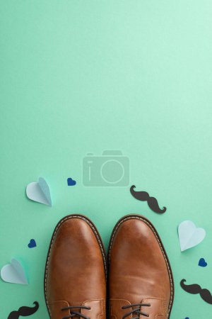 Photo for Elegant Father's Day theme. Flat lay top view of leather shoes mustaches, and hearts arranged on a teal background with space for text - Royalty Free Image