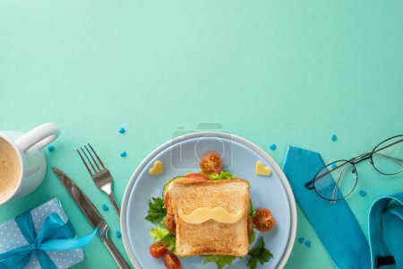 Foto de Sorprende a papá en el Día del Padre con el desayuno en la cama! Vista superior de sándwich con verduras, cubiertos, taza de café, corbata, gafas, caja de regalos, aspersiones, fondo verde azulado con espacio vacío - Imagen libre de derechos