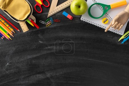 Photo for Dive into the inspiring classroom aesthetic with this top-down photograph: a blackboard featuring an artistic display of various stationery on an isolated background, ready for adverts or text - Royalty Free Image