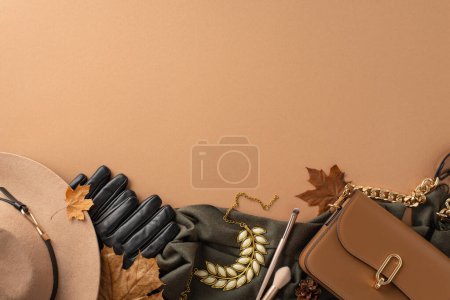 Téléchargez les photos : Concept de vêtements pour femmes intemporels inspiré de l'automne. Coup de tête de chapeau débordé, gants élégants en cuir, écharpe sophistiquée, sac à main, collier riche, brosses, feuilles, fond beige avec de la place pour le texte ou l'annonce - en image libre de droit