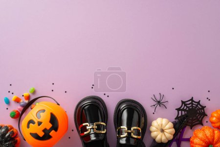 Téléchargez les photos : Plongez-vous dans la tradition festive Halloween trick-or-treat grâce à des photos aériennes de bonbons, chaussures pour enfants et décorations effrayantes sur fond isolé violet, offrant un espace abondant pour les annonces ou le texte - en image libre de droit