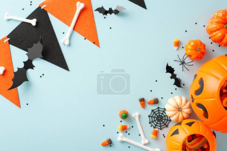 Wunderschöne Halloween-Süßigkeiten-Kollektion von Kindern. Bild von oben mit einem Kürbiskorb gefüllt mit Leckereien und Halloween-Dekorationen auf blauem Hintergrund, vielseitig einsetzbar für Text oder Werbung
