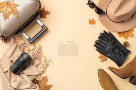 Téléchargez les photos : Prêt pour l'automne. Photo vue du dessus de valise grise, chapeau en feutre, bottes brunes, lunettes de soleil noires, écharpe en cachemire et gants en cuir sur fond isolé beige. Idéal pour votre promo de voyage ou texte - en image libre de droit