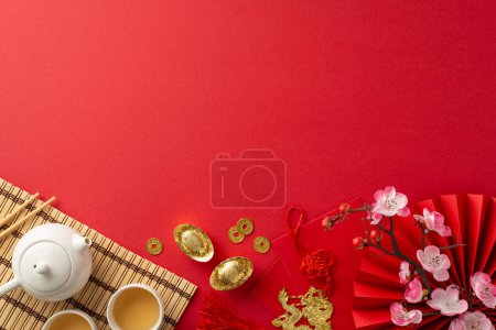 Photo for Traditional Chinese New Year Table: top view tea ceremony set, bamboo placemat, coins, red envelopes, dragon charm hanging, sakura and more on red backdrop. Create festive atmosphere for your promo - Royalty Free Image
