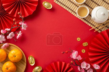 Photo for China's festive New Year spread: Overhead shot of traditional items, green tea ceremony set, bamboo placemat, plate with tangerines, sakura on vibrant red background, providing space for text or ads - Royalty Free Image
