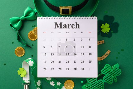 Photo for Celebrate St. Patrick's Day! Top view of a calendar, leprechaun hat, bow tie, suspenders, lucky horseshoe, party eyewear, and gold coins. Green background with trefoils, confetti, ready for notes - Royalty Free Image