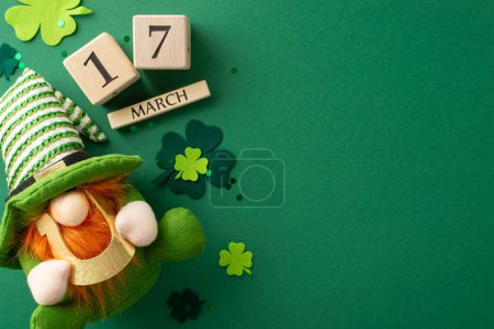 Photo for Top view shot of wooden calendar with date highlighted for joyous occasion, surrounded by dwarf toy, holding lucky horseshoe, trefoils, and confetti on a green backdrop - Royalty Free Image