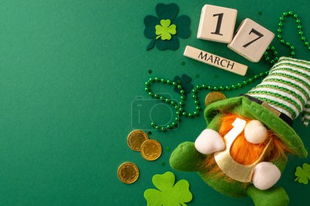 Photo for Overhead shot of wooden block calendar displaying the date for a festive celebration, surrounded by a leprechaun's gold, dwarf toy, lucky horseshoe, trefoils, confetti, beads on vibrant green backdrop - Royalty Free Image