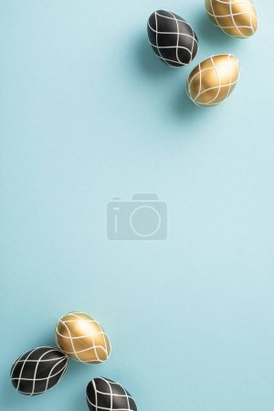 Foto de Exhibición vertical de la observancia de Pascua: Vista superior de los huevos negros y dorados, fijada contra un telón de fondo azul pastel, proporcionando espacio para el texto o la publicidad - Imagen libre de derechos