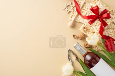 Téléchargez les photos : Elégant thème de table Seder, vue du dessus. Caractéristiques matzah entouré de ruban, bouteille de vin, noix, cuillère à miel, casse-noix, étoile de David et tulipes sur une surface beige clair, espace pour le libellé - en image libre de droit