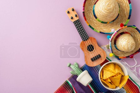Cinco de Mayo concept. Top view picture featuring characteristic gear: sombreros, stringed vihuela, a cactus, a bright serape, set on a pastel purple field, space for text