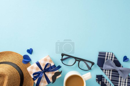 Eine Komposition zum Vatertag mit stylischem Hut, modernen Gläsern, Kaffeetasse und elegant verpacktem Geschenk auf blauem Hintergrund