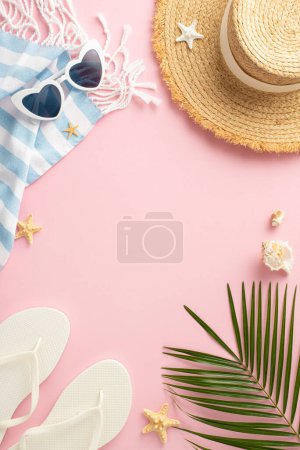 Vertical overhead view of summer holiday accessories spread out on a pink surface. The image features a straw hat, sunglasses, flip-flops, a beach towel, seashells, and a palm leaf