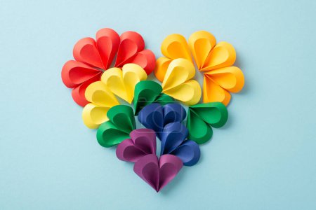 Chromatische Papierherzen in leuchtenden Farben bilden einen Regenbogen und symbolisieren Vielfalt und Einheit für den Pride Month in einer kreativen Ausstellung