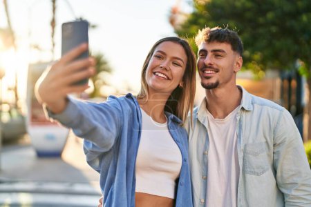 Foto de Joven pareja de hombres y mujeres sonriendo confiados haciendo selfie por el teléfono inteligente en la calle - Imagen libre de derechos