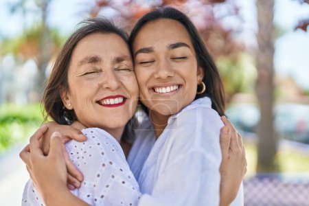 Téléchargez les photos : Two women mother and daughter smiling confident hugging each other at park - en image libre de droit