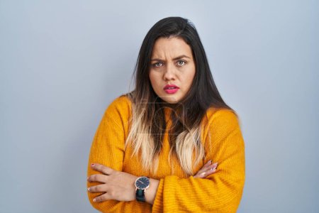 Photo for Young hispanic woman standing over isolated background skeptic and nervous, disapproving expression on face with crossed arms. negative person. - Royalty Free Image