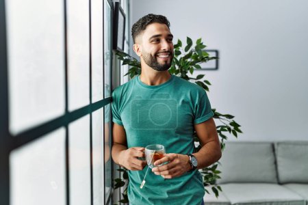 Photo for Young arab man smiling confident drinking tea at home - Royalty Free Image