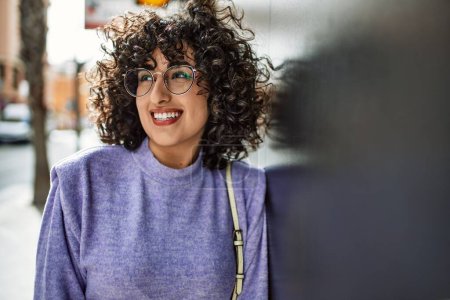 Photo for Young middle east woman smiling confident wearing glasses at street - Royalty Free Image