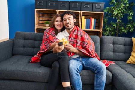 Téléchargez les photos : Homme et femme regardant un film s'embrasser à la maison - en image libre de droit