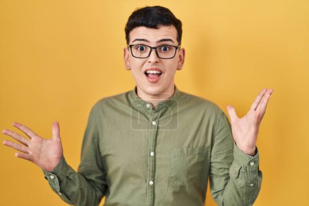 Photo for Non binary person standing over yellow background celebrating crazy and amazed for success with arms raised and open eyes screaming excited. winner concept - Royalty Free Image