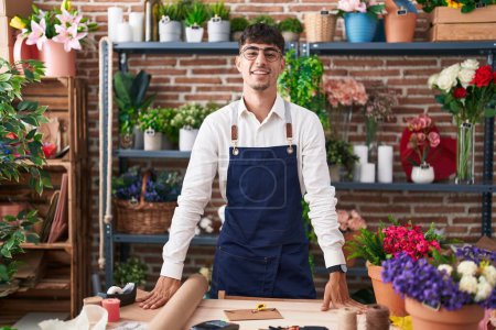 Téléchargez les photos : Young hispanic man florist smiling confident standing at florist - en image libre de droit