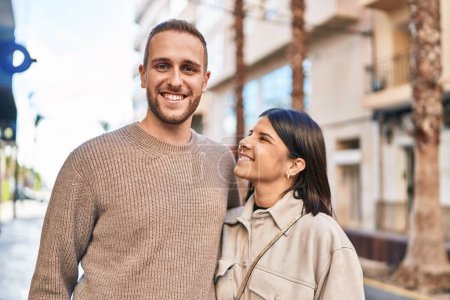 Téléchargez les photos : Homme et femme couple souriant confiant étreinte l'un l'autre debout à la rue - en image libre de droit