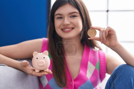 Photo for Young caucasian woman smiling confident holding uniswap coin and piggy bank at home - Royalty Free Image