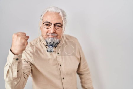 Photo for Middle age man with grey hair standing over isolated background angry and mad raising fist frustrated and furious while shouting with anger. rage and aggressive concept. - Royalty Free Image