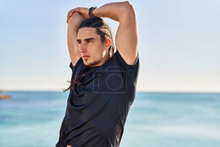 Photo for Young man stretching arms at seaside - Royalty Free Image