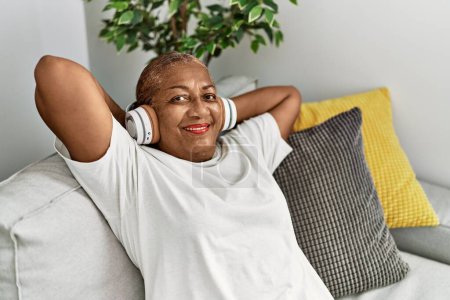 Senior african american woman smiling confident listening to music at home