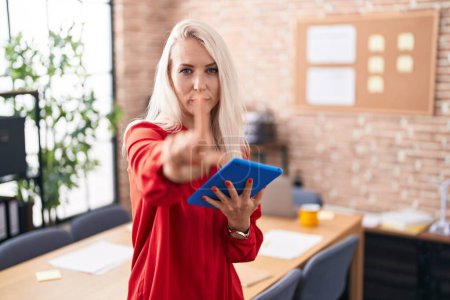 Téléchargez les photos : Caucasian woman working at the office with tablet pointing with finger up and angry expression, showing no gesture - en image libre de droit