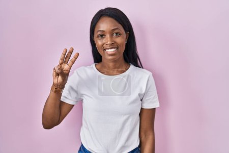 Photo for African young woman wearing casual white t shirt showing and pointing up with fingers number three while smiling confident and happy. - Royalty Free Image