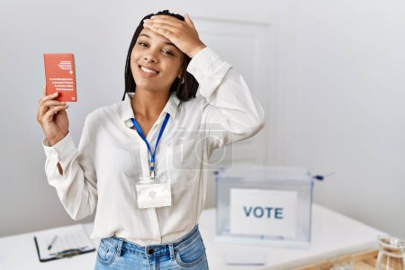 Foto de Mujer afroamericana joven en las elecciones de campaña política con pasaporte suizo estresado y frustrado con la mano en la cabeza, cara sorprendida y enojada - Imagen libre de derechos