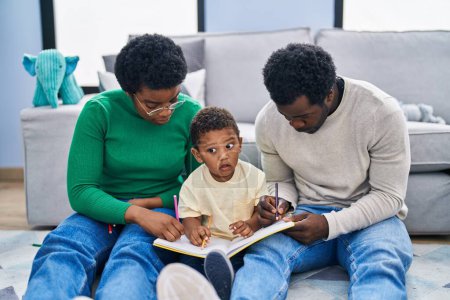 Foto de Dibujo familiar afroamericano en cuaderno sentado en el suelo en casa - Imagen libre de derechos