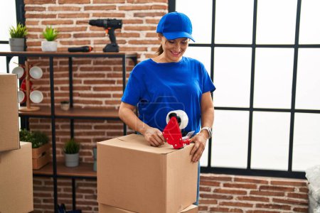 Téléchargez les photos : Femme d'âge moyen déplacement travailleur emballage boîte en carton à la nouvelle maison - en image libre de droit