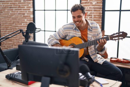 Téléchargez les photos : Jeune musicien hispanique jouant de la guitare classique au studio de musique - en image libre de droit