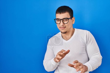 Téléchargez les photos : Young arab man wearing casual white shirt and glasses disgusted expression, displeased and fearful doing disgust face because aversion reaction. with hands raised - en image libre de droit
